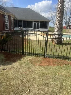 Black aluminum residential fence with decorative arched gate